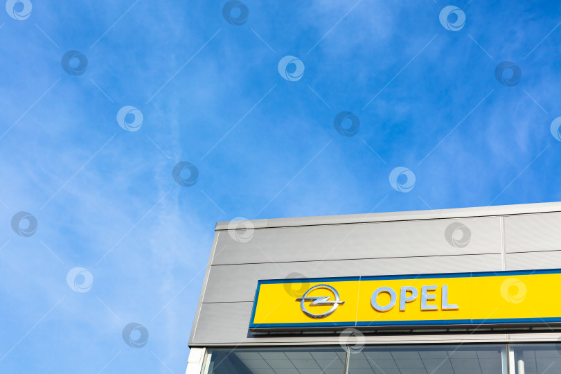 Скачать Логотип бренда Opel на фоне ярко-голубого неба фотосток Ozero