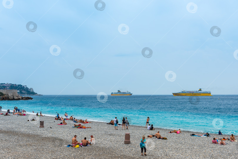 Скачать Люди на пляже Средиземного моря в Ницце фотосток Ozero