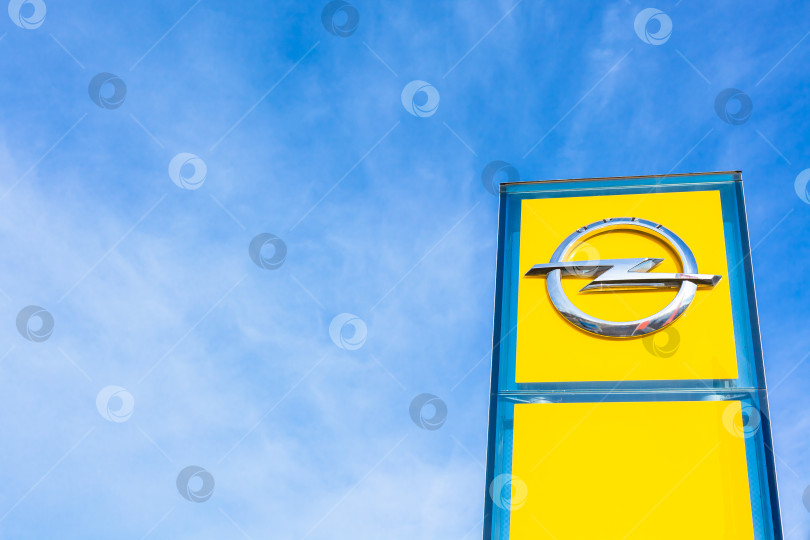 Скачать Логотип бренда Opel на фоне ярко-голубого неба фотосток Ozero