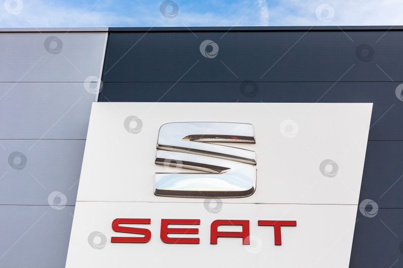 Скачать Логотип бренда SEAT на фоне ярко-голубого неба фотосток Ozero