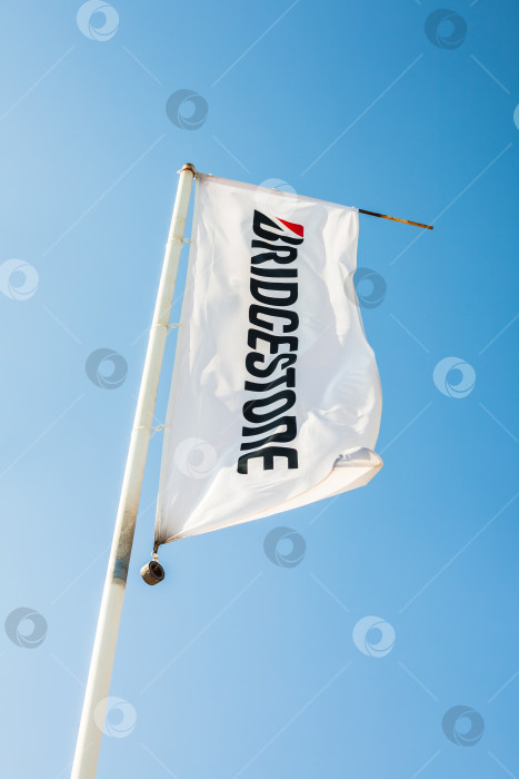 Скачать Флаг Bridgestone с логотипом на фоне голубого неба фотосток Ozero