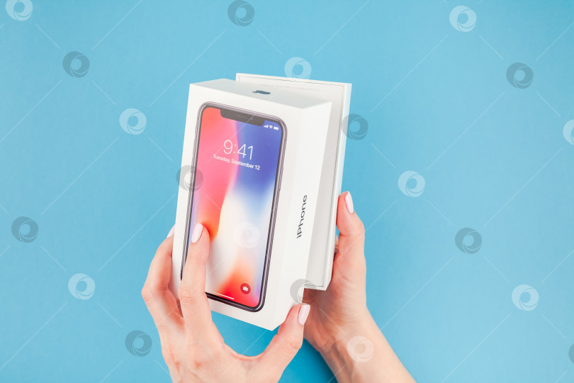 Скачать Женщина протягивает коробку с Apple iPhone X фотосток Ozero
