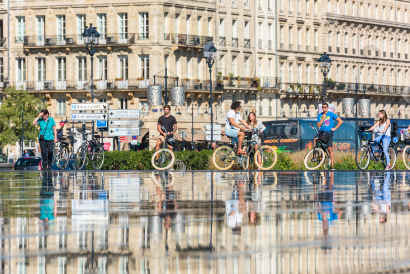 Скачать Люди катаются на велосипедах у фонтана в Бордо, Франция фотосток Ozero