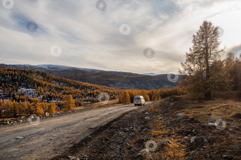 Скачать Белый автомобиль на горной осенней трассе для бездорожья фотосток Ozero