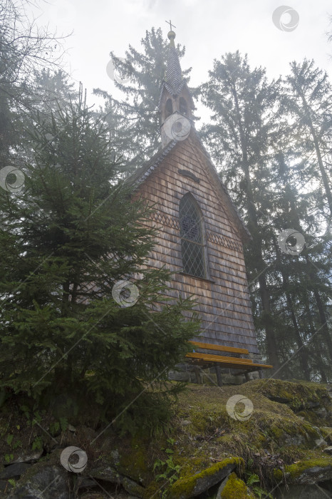 Скачать Маленькая часовня в лесу на склоне горы. фотосток Ozero