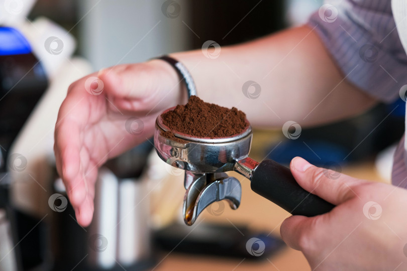 Скачать Кофемолка для кофейных зерен. Измельчите кофейный порошок обеими руками. Кофейный порошок находится в ручке кофемашины. фотосток Ozero