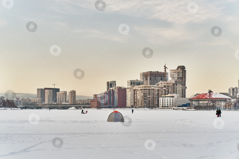 Скачать Зимний городской пейзаж Екатеринбурга, Россия. Лед городского пруда покрыт снегом, палатка рыбака. фотосток Ozero