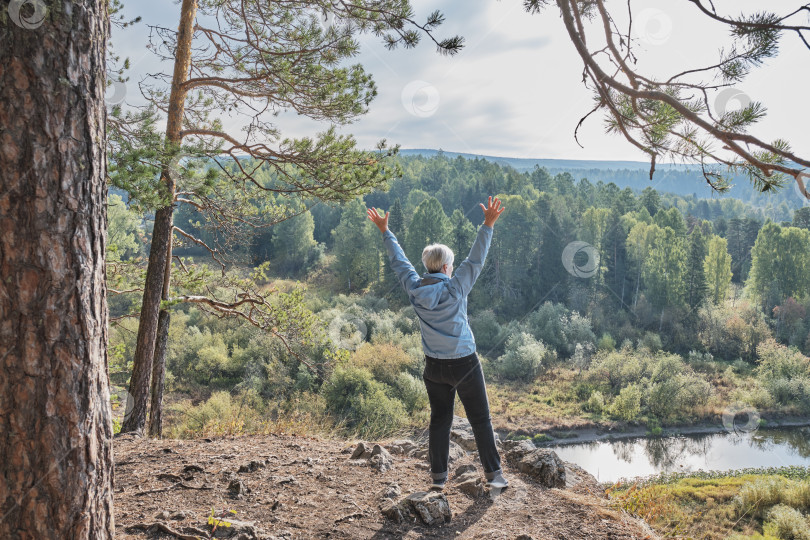 Скачать Старшая туристка на скале в природном парке Оленьи ручьи, Россия фотосток Ozero