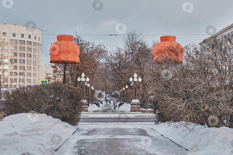 Скачать Зимний городской пейзаж Екатеринбурга, Россия. Два уютных домашних оранжевых абажура на фонарях на городской аллее фотосток Ozero