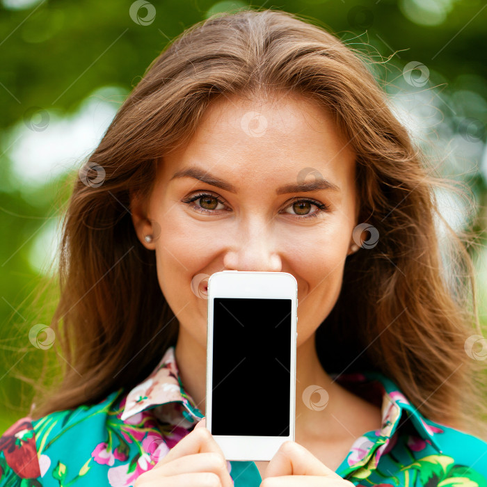 Скачать Молодая красивая девушка показывает экран своего смартфона фотосток Ozero