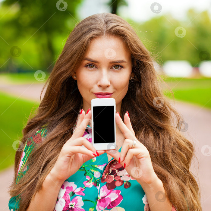 Скачать Молодая красивая девушка показывает экран своего смартфона фотосток Ozero