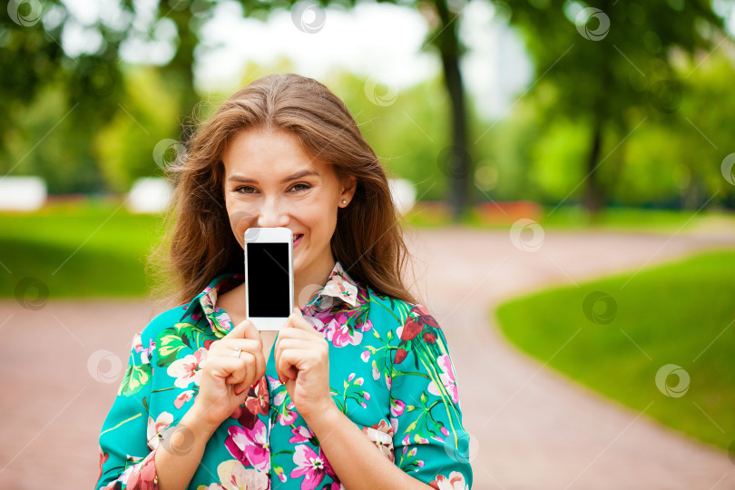 Скачать Молодая красивая девушка показывает экран своего смартфона фотосток Ozero