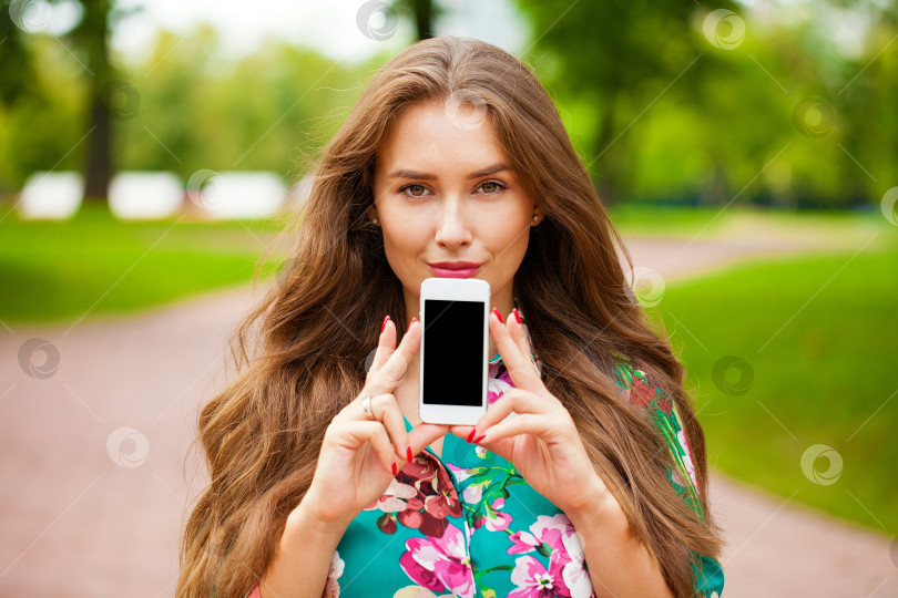 Скачать Молодая красивая девушка показывает экран своего смартфона фотосток Ozero