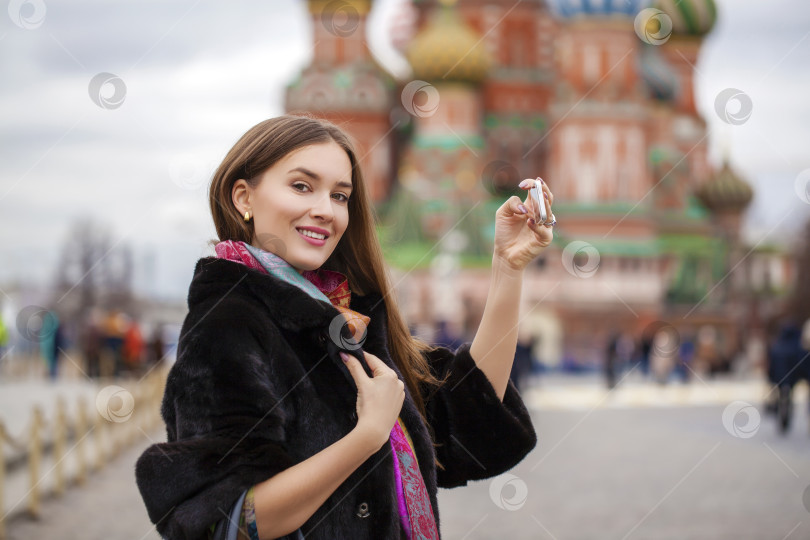 Скачать Молодая красивая туристка фотографирует на мобильный телефон фотосток Ozero