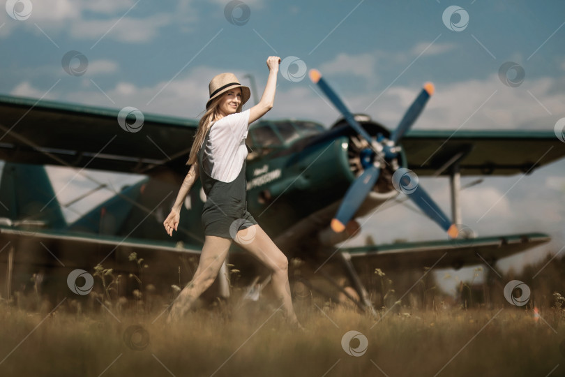 Скачать женщина в соломенной шляпе на заднем плане позирует на фоне самолета с пропеллером фотосток Ozero