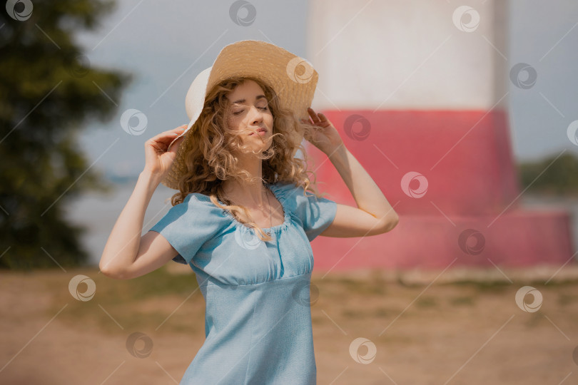 Скачать девушка в голубом платье и большой соломенной шляпе наслаждается солнцем на открытом воздухе фотосток Ozero