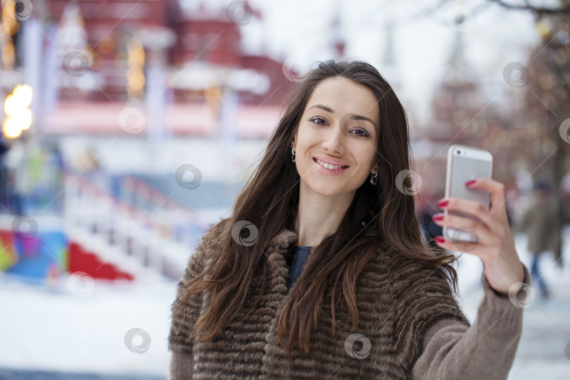 Скачать Молодая красивая туристка фотографирует на мобильный телефон фотосток Ozero