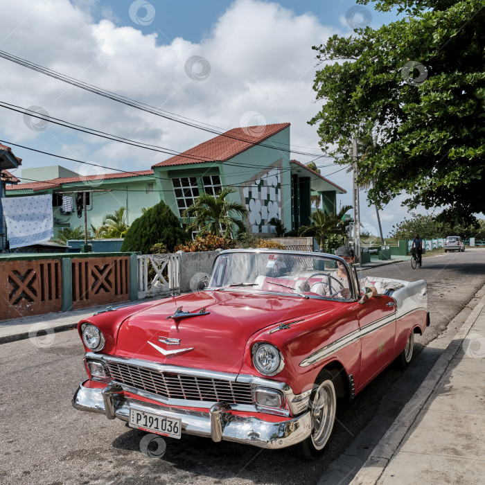 Скачать Красно-белый ретро-автомобиль Chevrolet 1957 года выпуска на улице курортного города Варадеро, Куба. фотосток Ozero