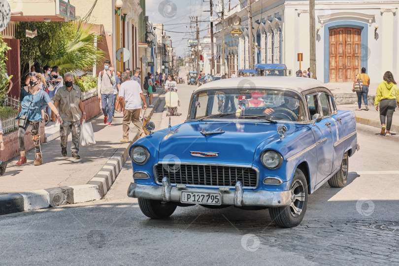 Скачать Синий ретро-автомобиль Chevrolet движется по улице города Санта-Клара, Куба. фотосток Ozero