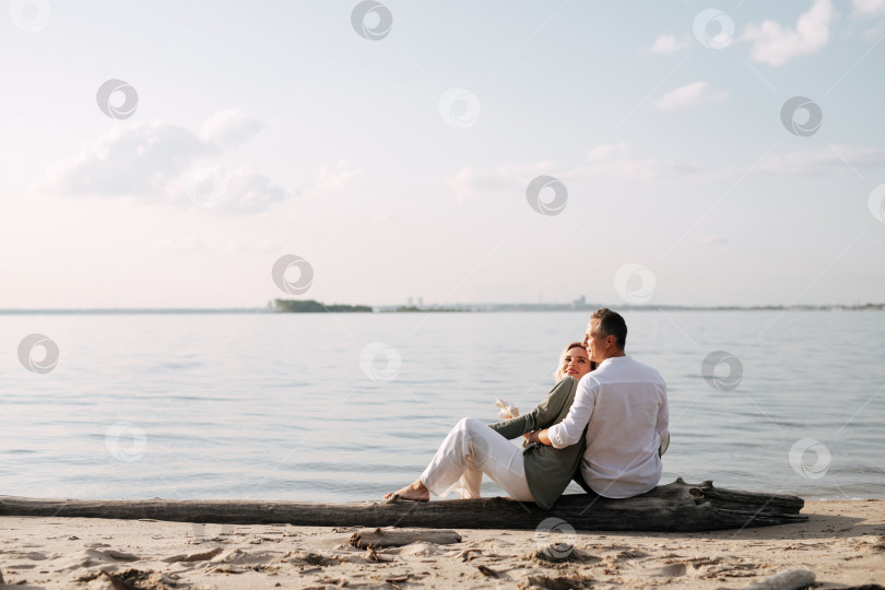 Скачать мужчина и женщина сидят на бревне у моря и смотрят вдаль фотосток Ozero