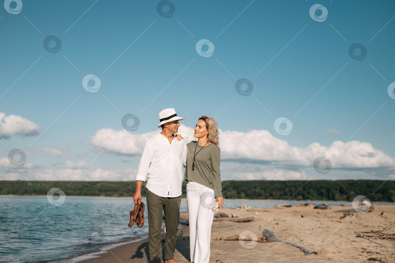 Скачать Женщина и мужчина прогуливаются по пляжу в солнечную погоду фотосток Ozero