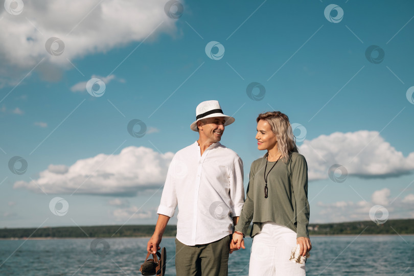 Скачать Женщина и мужчина прогуливаются по пляжу в солнечную погоду фотосток Ozero