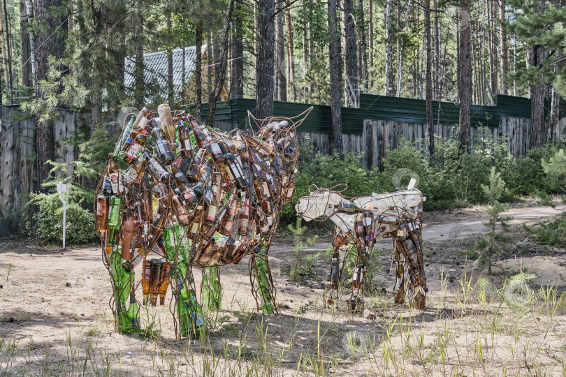 Скачать Скульптуры коровы, теленка сделаны из мусора. Использованы стеклянные бутылки в каркасе из железной арматуры фотосток Ozero