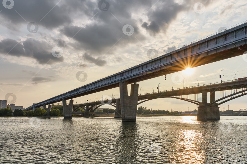 Скачать Новосибирский метромост через реку Обь в Новосибирске, Россия. Городской пейзаж на закате фотосток Ozero