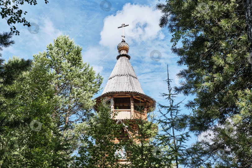 Скачать Купол и колокольня современной бревенчатой церкви с шатровой крышей. Русское деревянное зодчество. фотосток Ozero