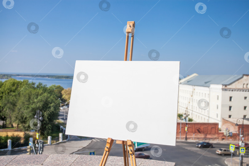 Скачать Пустой белый холст на треноге, летняя улица фотосток Ozero