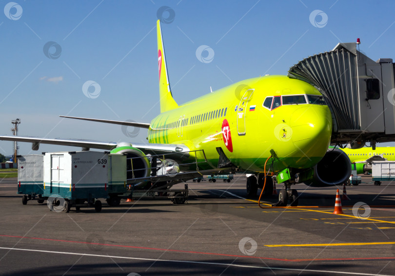 Скачать Самолет авиакомпании "S7 Airlines" при переходе по телескопическому трапу в аэропорту Домодедово фотосток Ozero