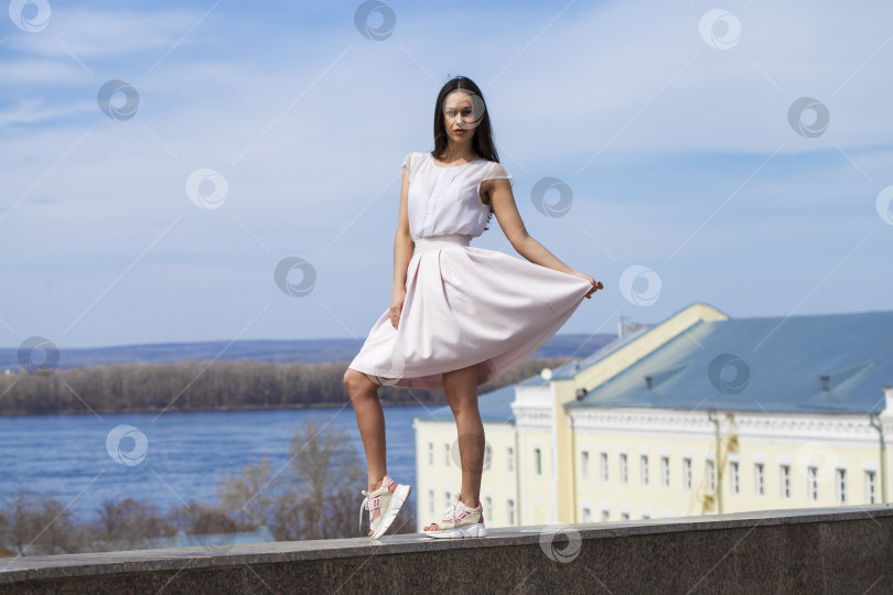 Скачать Молодая брюнетка в розовой юбке и белой блузке фотосток Ozero
