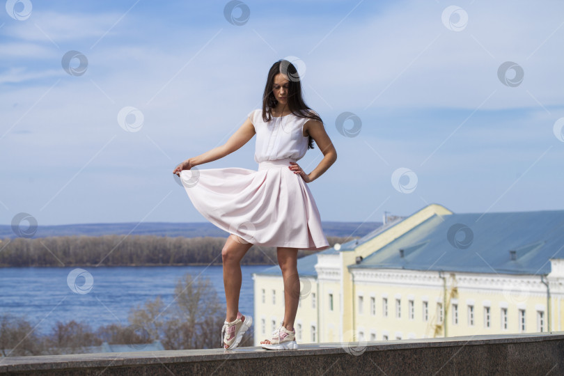 Скачать Молодая брюнетка в розовой юбке и белой блузке фотосток Ozero