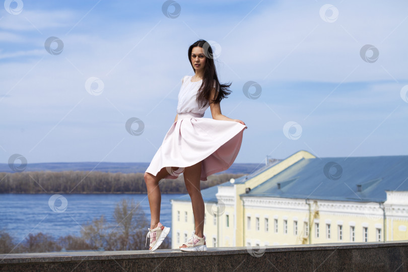 Скачать Молодая брюнетка в розовой юбке и белой блузке фотосток Ozero