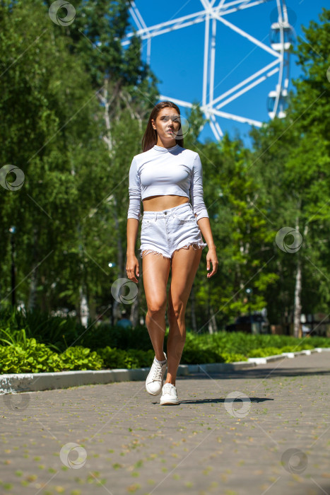 Скачать Портрет молодой красивой брюнетки в белых джинсовых шортах фотосток Ozero