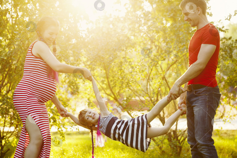 Скачать Семья. Муж, беременная жена и дочь на открытом воздухе фотосток Ozero