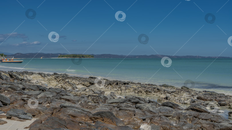 Скачать Скалистый берег океана. У бирюзовой воды разбросаны валуны фотосток Ozero