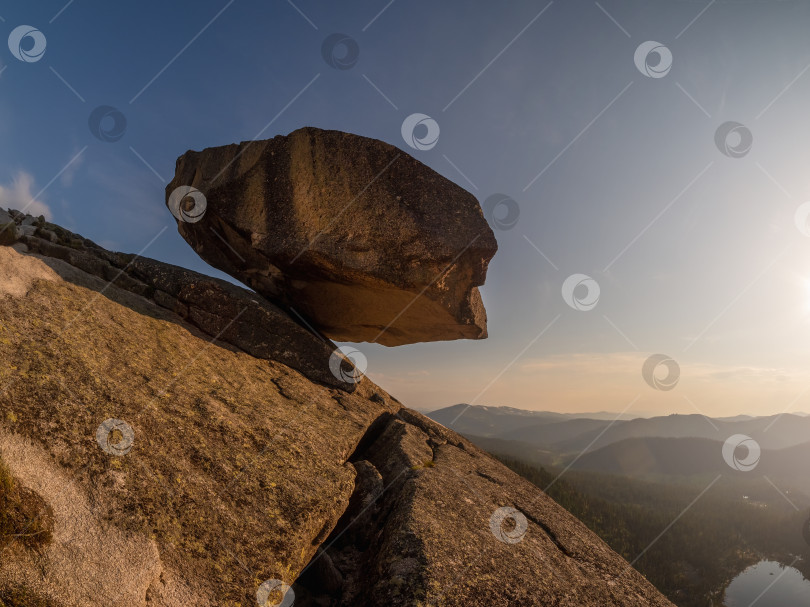 Скачать Большой гранитный валун нависает над пропастью. фотосток Ozero