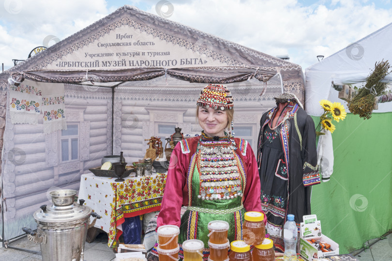 Скачать Портрет азиатской женщины в яркой красочной национальной башкирской праздничной одежде. Ирбитская ярмарка, Россия фотосток Ozero