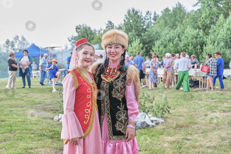 Скачать Две азиатские девушки в традиционной этнической одежде на деревенском фестивале, Сибирь, Россия фотосток Ozero