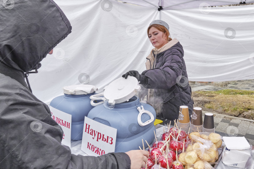 Скачать Женщина, продающая традиционные казахские угощения во время празднования Навруза, Алматы, Казахстан фотосток Ozero