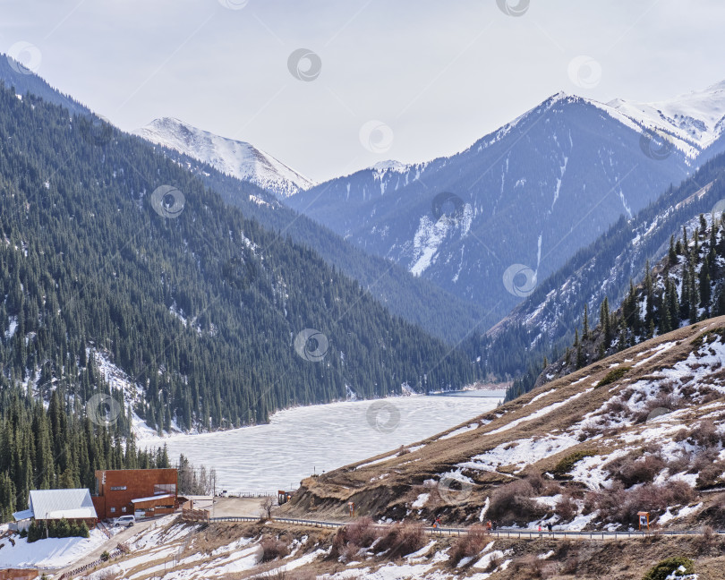 Скачать Спуск к озеру Нижний Кольсай, покрытому льдом, Казахстан. фотосток Ozero