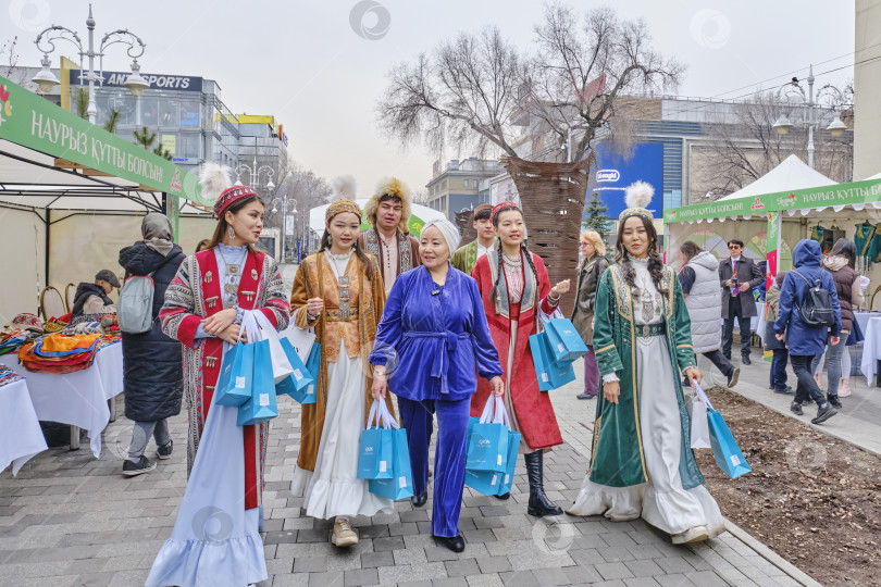 Скачать Группа людей в традиционной национальной казахской одежде прогуливается по ярмарке ремесел, Алматы, Казахстан фотосток Ozero