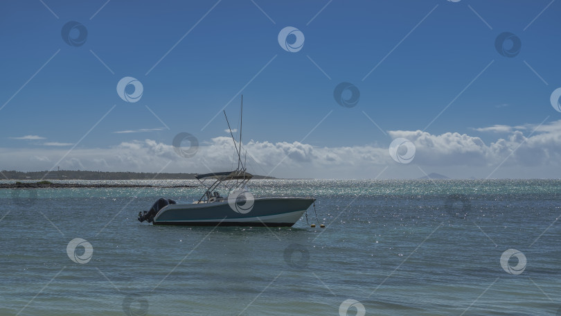 Скачать Моторная лодка стоит на якоре в спокойном бирюзовом океане. фотосток Ozero