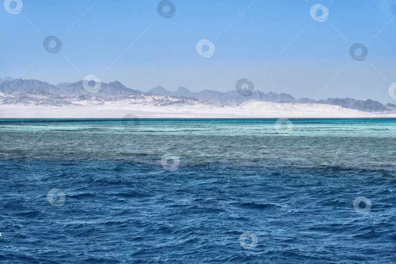 Скачать Вид на Красное море с ярко-голубыми водами и далекие засушливые горы под ясным небом фотосток Ozero