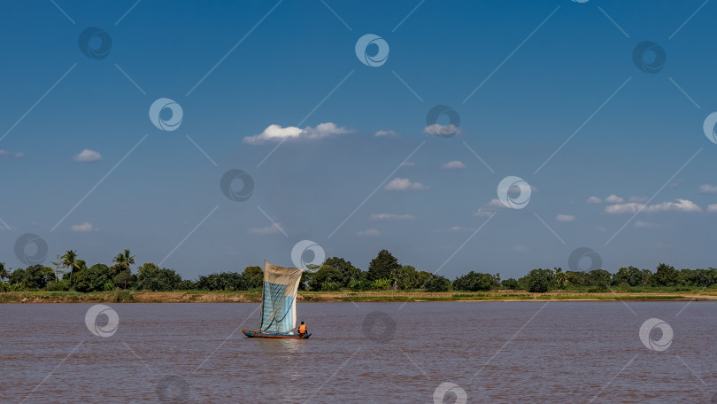 Скачать Лодка плывет по красно-коричневой африканской реке. фотосток Ozero