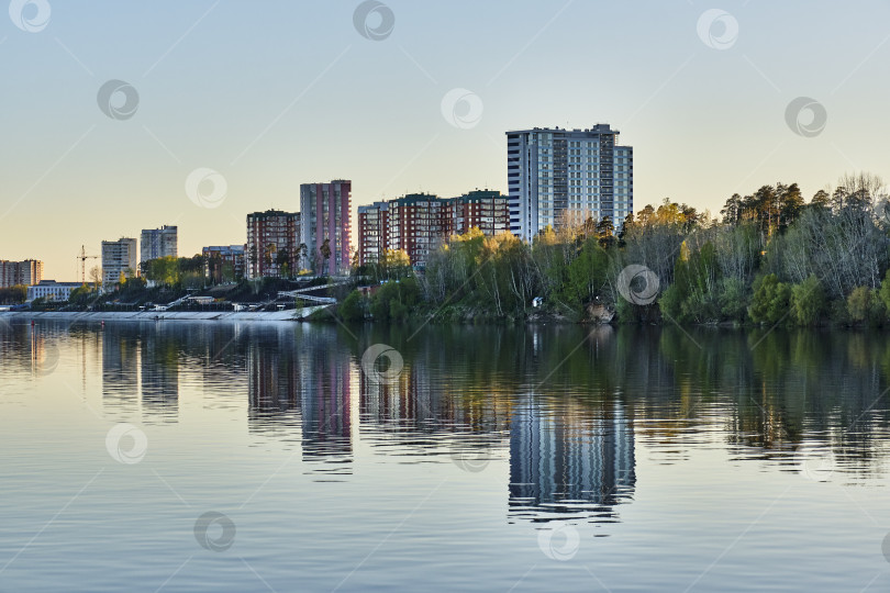 Скачать Жилые дома и набережная города Краснокамска, Россия. Вид с реки Кама на закате фотосток Ozero