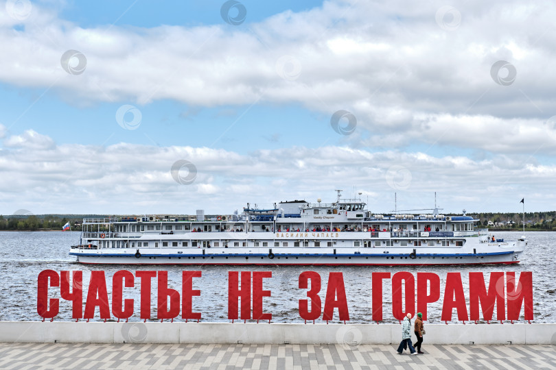 Скачать Круизный лайнер, плывущий за текстом "Счастье не за горами" по набережной реки Камы, Пермь, Россия фотосток Ozero