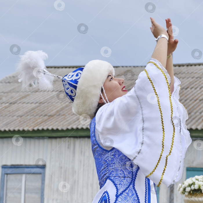 Скачать Портрет молодой симпатичной танцующей азиатки в профиль, в традиционной праздничной башкирской одежде фотосток Ozero