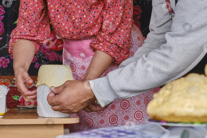 Скачать Руки женщины-кулинара и мужчины вместе формуют тесто для баурсака на кулинарном мастер-классе фотосток Ozero